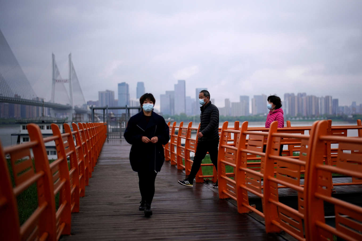 People wearing face masks walk, in Wuhan, Hubei province, the epicenter of China's coronavirus disease (COVID-19) outbreak, March 29, 2020. REUTERS/Aly Song