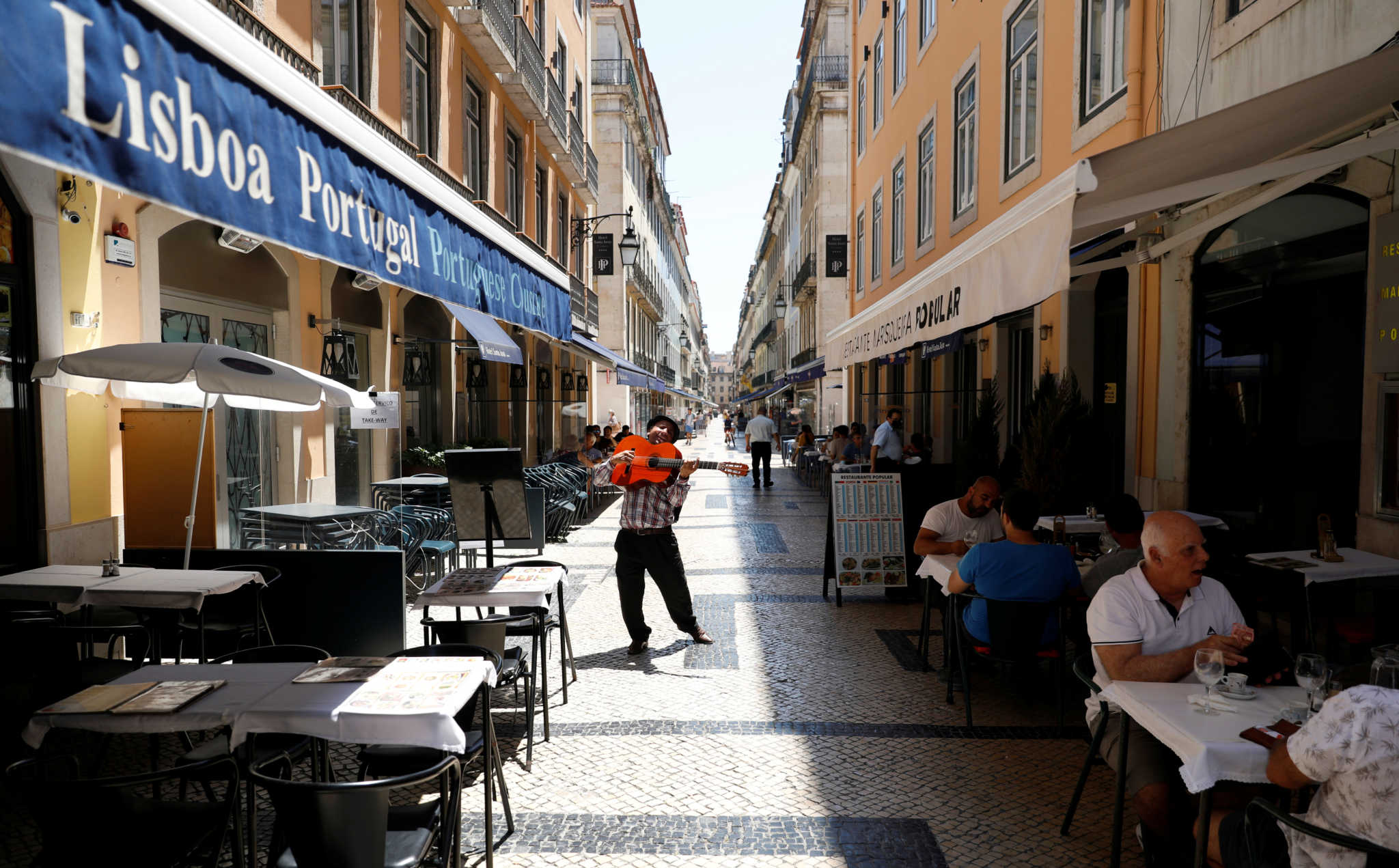 A street musician plays next to restaurants, amid the coronavirus disease (COVID-19) outbreak, in Lisbon, Portugal June 23, 2020. REUTERS/Rafael Marchante