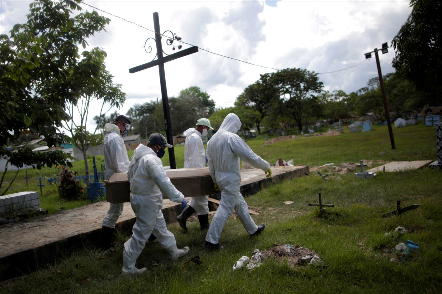 Gravediggers wearing protective suits prepare to bury the coffin of 70-year-old Manuel Farias, who died from the coronavirus disease (COVID-19), at Recanto da Paz cemetery, in Breves, southwest of Marajo island in Para state, Brazil, June 7, 2020. REUTERS/Ueslei Marcelino