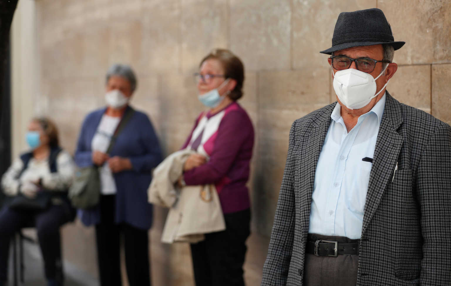 People wearing protective face masks attend the rosary prayer on a street ahead of Masses being allowed to resume inside churches from May 18 due to the spread of the coronavirus disease (COVID-19), in Rome, Italy May 14, 2020. REUTERS/Yara Nardi