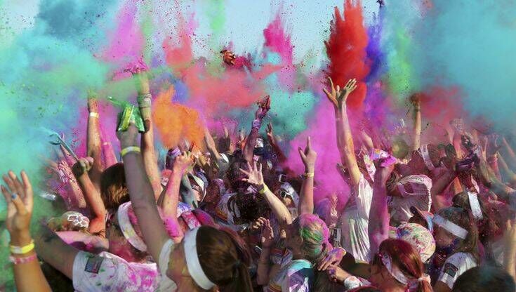 People throw colored powder in the air during a party festival of the Color Run in Sydney, Australia, Sunday, Feb. 9, 2014. The Color Run event is a 5 km (3.1 mile) fun run where participants are covered with bright colored powder at each check station and is less about speed and more about enjoying a color crazy day with friends and family.(AP Photo/Rob Griffith)