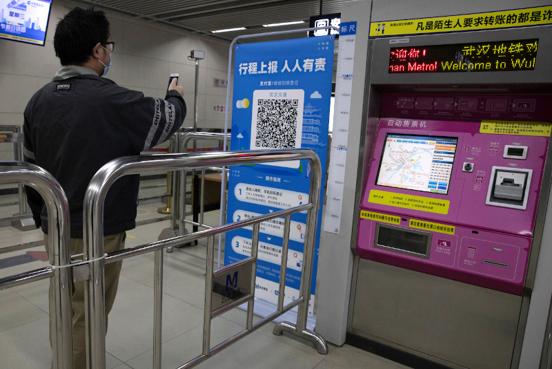 In this April 1, 2020 photo, a passenger scans a QR code to get his green pass at a subway station in Wuhan in central China's Hubei province. Life in China post-coronavirus outbreak is ruled by a green symbol on a smartphone screen. Green signifies the "health code" that says the user is symptom-free. It is required to board a subway, check into a hotel or enter Wuhan, the city where the global pandemic began. (AP Photo/Ng Han Guan)