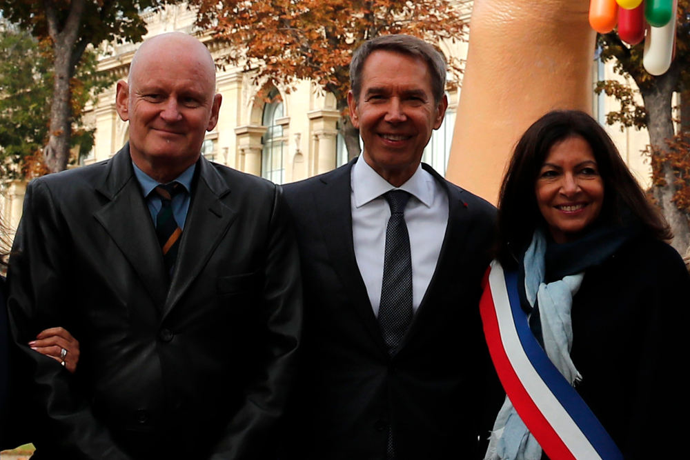 FILE - In this Oct.4, 2019 file photo, New York-based artist Jeff Koons, center, poses with Mayor of Paris Anne Hidalgo, right, and Christophe Girard, deputy Paris mayor in charge of culture, as they unveiled the sculpture "Bouquet of Tulips" dedicated to the victims of the terrorists attacks, in Paris. The Paris prosecutor's office announced a preliminary investigation Tuesday Aug.18 2020 into allegations of rape by a person of authority, targeting former deputy mayor Christophe Girard. The probe was prompted by accusations by a Tunisian man published in the New York Times. (AP Photo/Francois Mori, File)