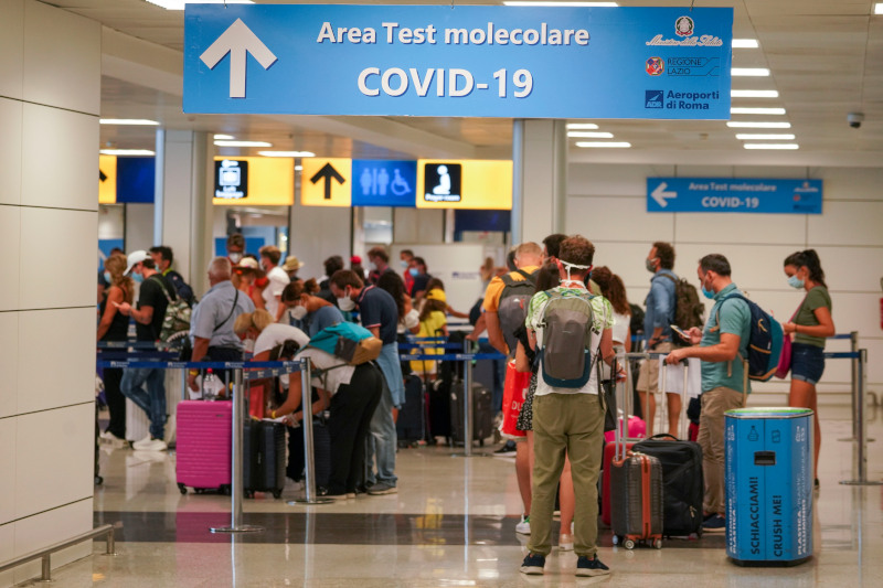 Vacationers arriving in Rome from four Mediterranean countries line up with their suitcases at Rome's Leonardo da Vinci airport to be immediately tested for COVID-19, Sunday, Aug.16, 2020. Italy's health minister issued an ordinance requiring the tests for all travelers arriving in Italy from Croatia, Greece, Malta or Spain. (AP Photo/Andrew Medichini)