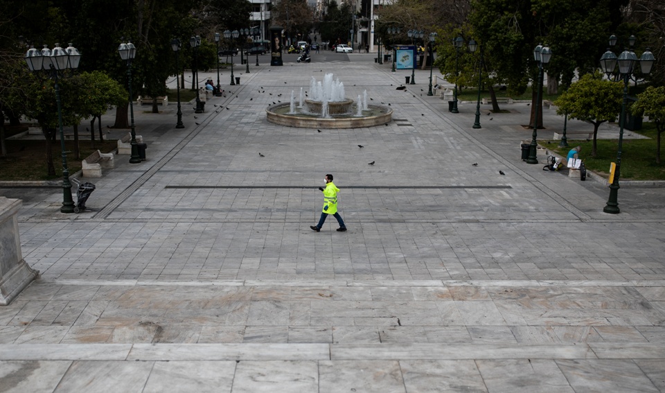 A municipal worker wearing a protective face mask walks on the empty Syntagma square, after the Greek government imposed a nationwide lockdown to contain the spread of the coronavirus disease (COVID-19), in Athens, Greece, March 23, 2020. REUTERS/Alkis Konstantinidis