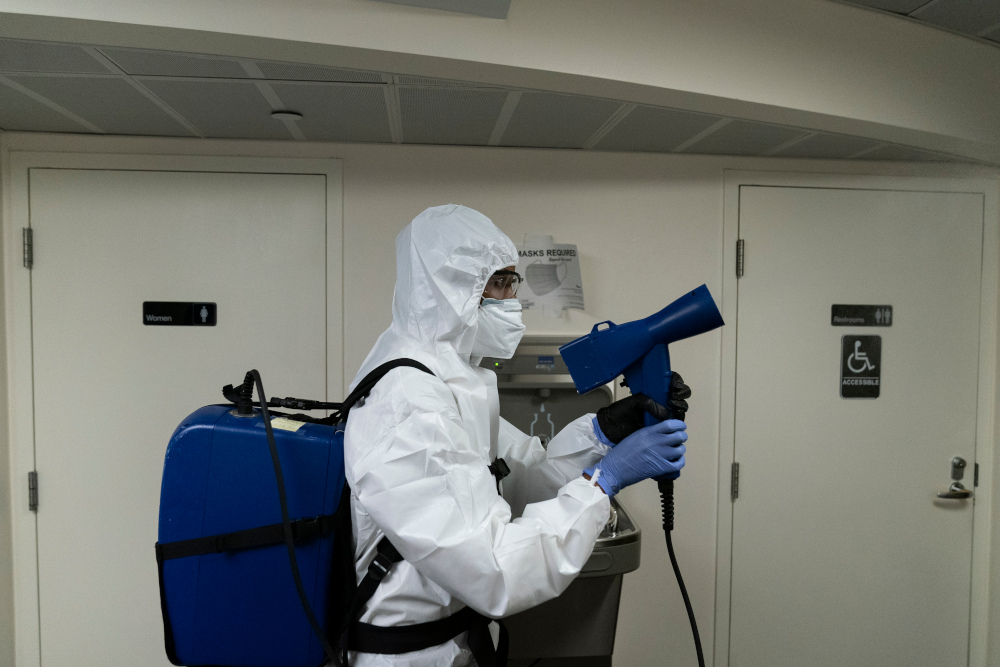 A member of the cleaning staff sprays press areas of the White House, Monday, Oct. 5, 2020, in Washington. (AP Photo/Alex Brandon)