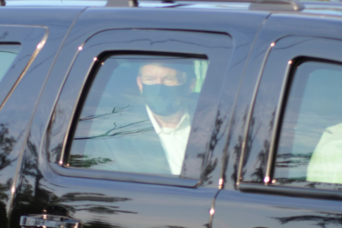 President Donald Trump drives past supporters gathered outside Walter Reed National Military Medical Center in Bethesda, Md., Sunday, Oct. 4, 2020. Trump was admitted to the hospital after contracting COVID-19. (AP Photo/Anthony Peltier)