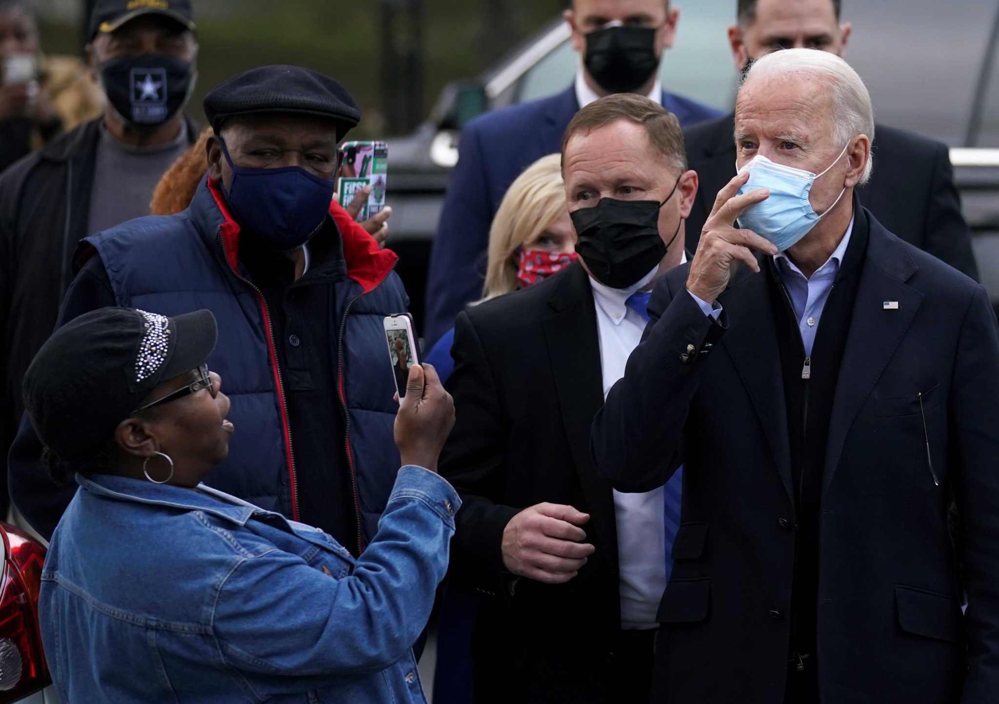 A woman takes a photo of U.S. Democratic presidential nominee Joe Biden as he visits a neighborhood in Wilmington, on Election Day, Delaware, U.S. November 3, 2020. REUTERS/Kevin Lamarque