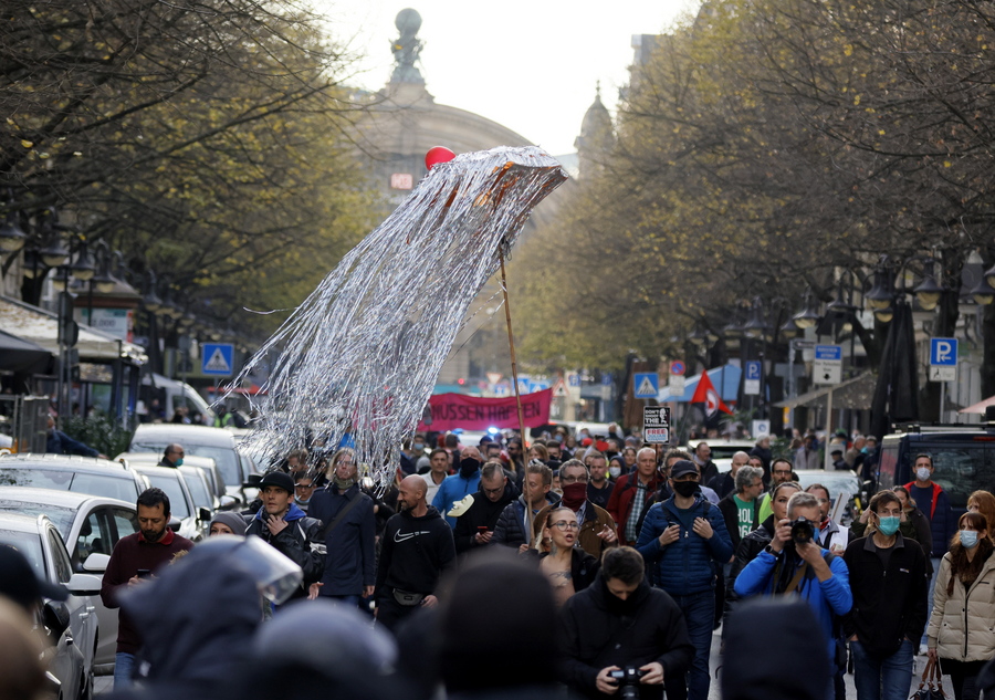 epa08819998 A protester holds an umbrella decorated with aluminum strips during a demonstration against the coronavirus restrictions, in Frankfurt am Main, Germany, 14 November 2020. The protests organized by the Third Position movement 'Querdenken' were held against government-imposed semi-lockdown measures aimed at curbing the spread of the coronavirus pandemic. Starting 02 November, all restaurants, bars, cultural venues, fitness studious, cinemas and sports halls will be forced to close for four weeks as a lockdown measure to rein in skyrocketing coronavirus infection rates. EPA/RONALD WITTEK