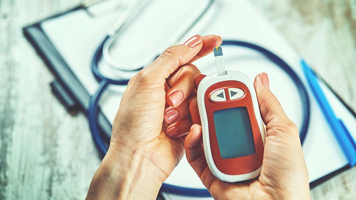 Close-up Of A Women's Hand Checking Blood Sugar Level With Glucometer