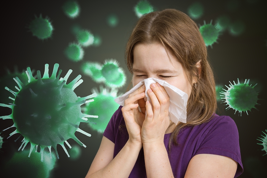 Ill woman has flu and is sneezing. Many viruses and germs flying around.