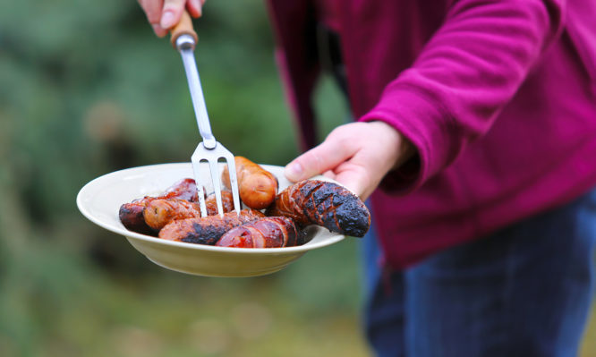 Grilled sausages served on a plate in the garden