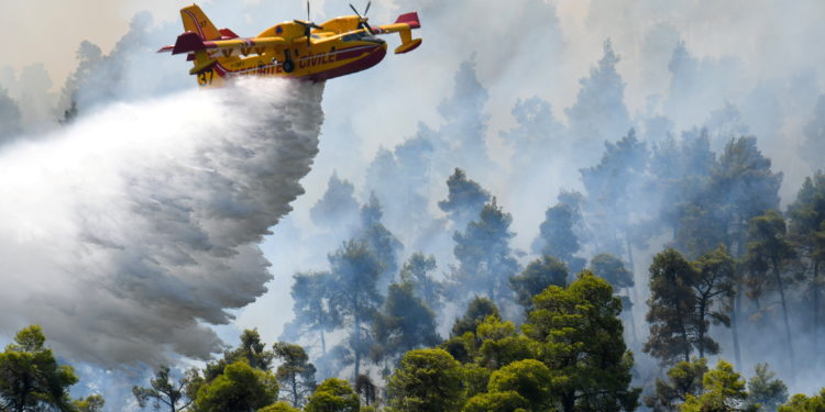 A firefighting airplane makes a water drop as a wildfire burns near the village of Ellinika, on the island of Evia, Greece, August 8, 2021. REUTERS/Alexandros Avramidis     TPX IMAGES OF THE DAY