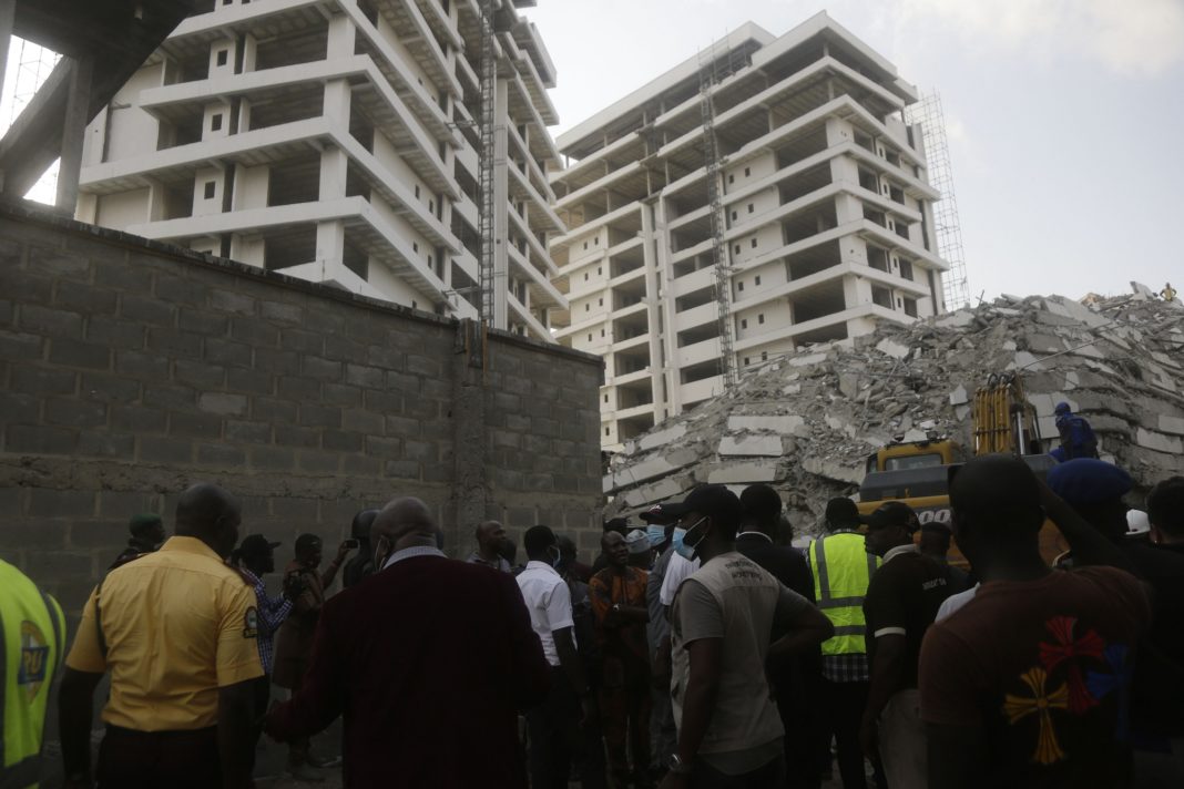 Rescue workers are seen at the site of a collapsed 21-story apartment building under construction in Lagos, Nigeria, Monday, Nov. 1, 2021. At least two people were killed and dozens more remain missing after the collapse of a 21-story apartment building being built in an upscale area of Nigeria's largest city, witnesses said on Monday.(AP Photo/Sunday Alamba)