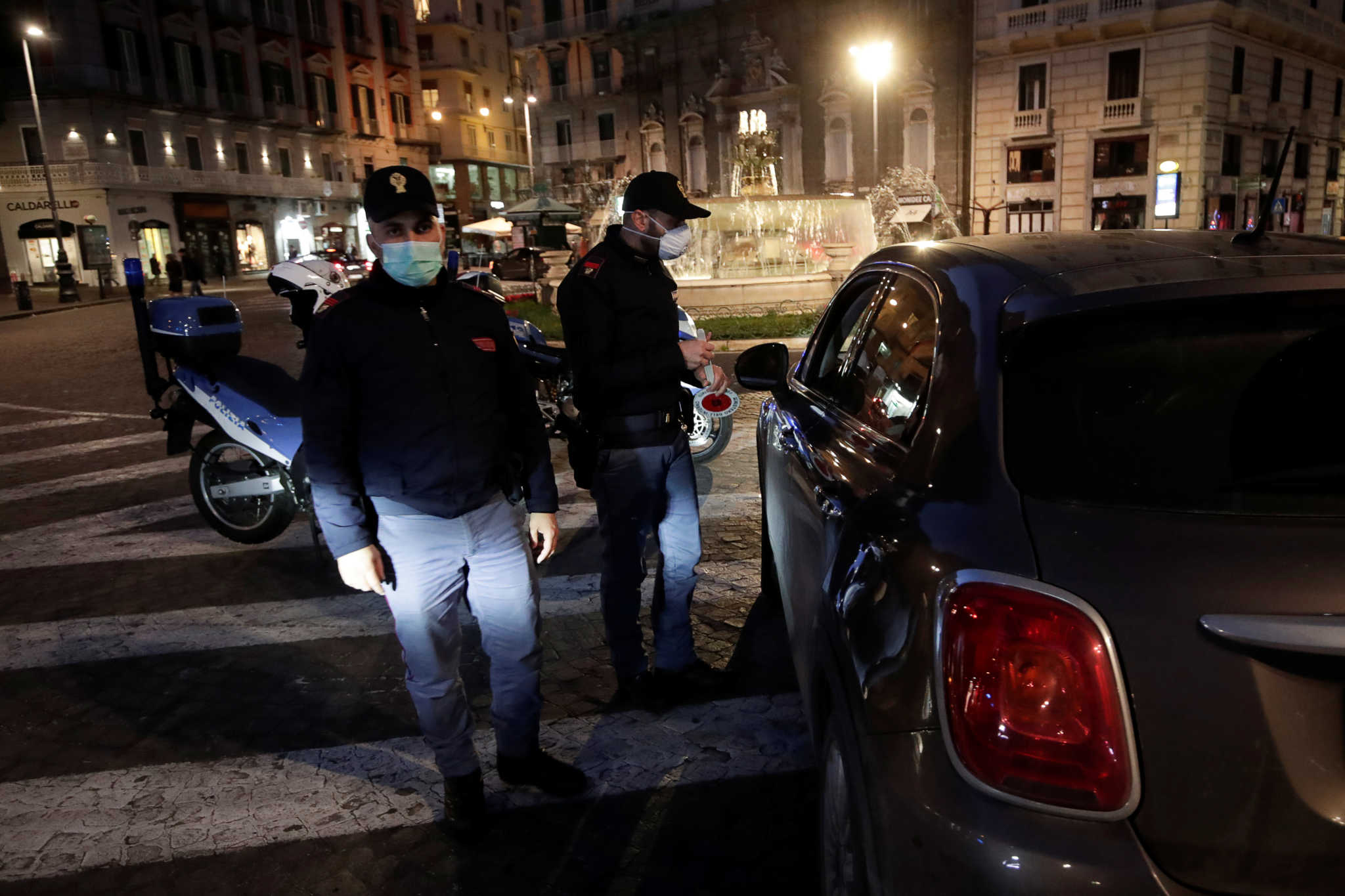 Police officers wear protective face masks at a checkpoint on the second day of an unprecedented lockdown across all of the country, imposed to slow the outbreak of coronavirus, in Naples, Italy March 11, 2020. REUTERS/Ciro de Luca