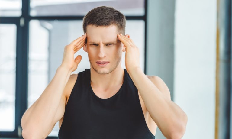 portrait-of-man-in-sportswear-having-headache-picture-id912640412-768x460