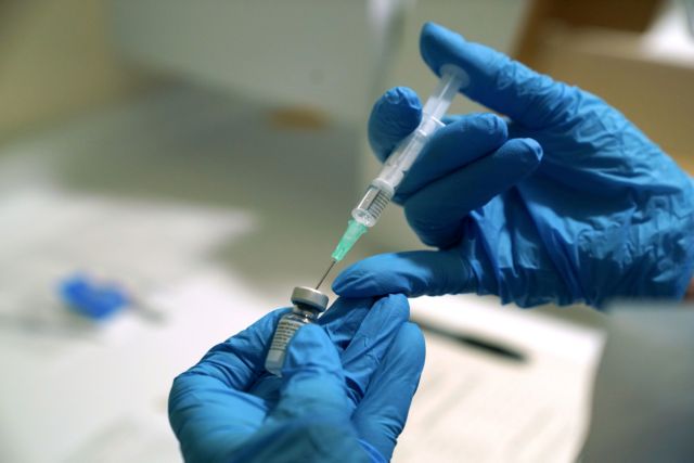 FILE PHOTO: A needle is filled from a phial of Pfizer/BioNTech COVID-19 vaccine at the Royal Victoria Infirmary, on the first day of the largest immunisation programme in the British history, in Newcastle, Britain December 8, 2020. Owen Humphreys/Pool via REUTERS/File Photo