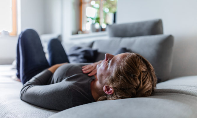 Close up of an ill woman in quarantine lying on the couch