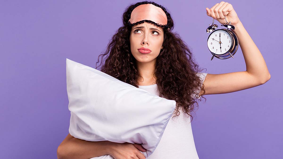 Portrait of her she nice cute charming attractive depressed brunette wavy-haired lady holding in hands pillow clock isolated on bright vivid shine violet purple background.