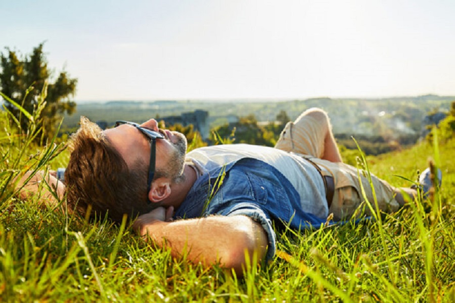 Man lying on grass enjoying peaceful sunny day