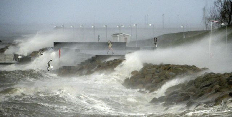 epa03979364 A lone storm spotter stands in the driving foam from the sea in Malmo, Southern Sweden, 06 December 2013. Several northern European countries were restoring transport and electricity services on 05 December after a powerful storm that killed at least three people started to abate. The three people killed by the storm included victims in Scotland, England and Denmark.  EPA/JOHAN NILSSON