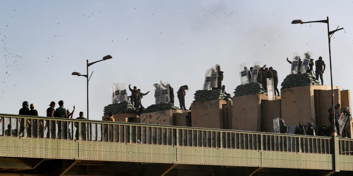 Police officers stay on guard as demonstrators gather during an anti-government protest, after a parliament session, in Baghdad, Iraq September 28, 2022. REUTERS/Thaier Al-Sudani