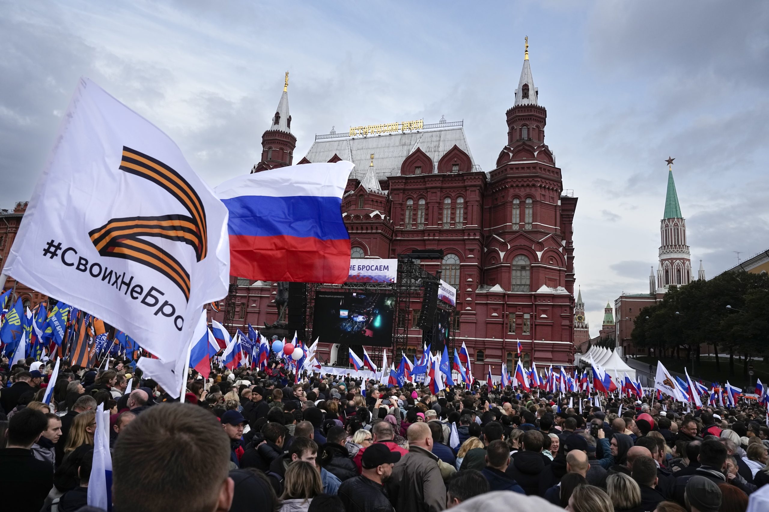 Demonstrators hold Russian state flags and flags with with the letter Z, which has become a symbol of the Russian military, and a hashtag reading "We don't abandon our own" during the action "We do not abandon our own" to support the referendum, on Manezhnaya Square near the Kremlin and Red Square with the Historical Museum in the background in Moscow, Russia, Friday, Sept. 23, 2022. The All-Russia People's Front organized a rally in support of the referendums in the four Moscow-held regions of Ukraine to become part of Russia. (AP Photo/Alexander Zemlianichenko)