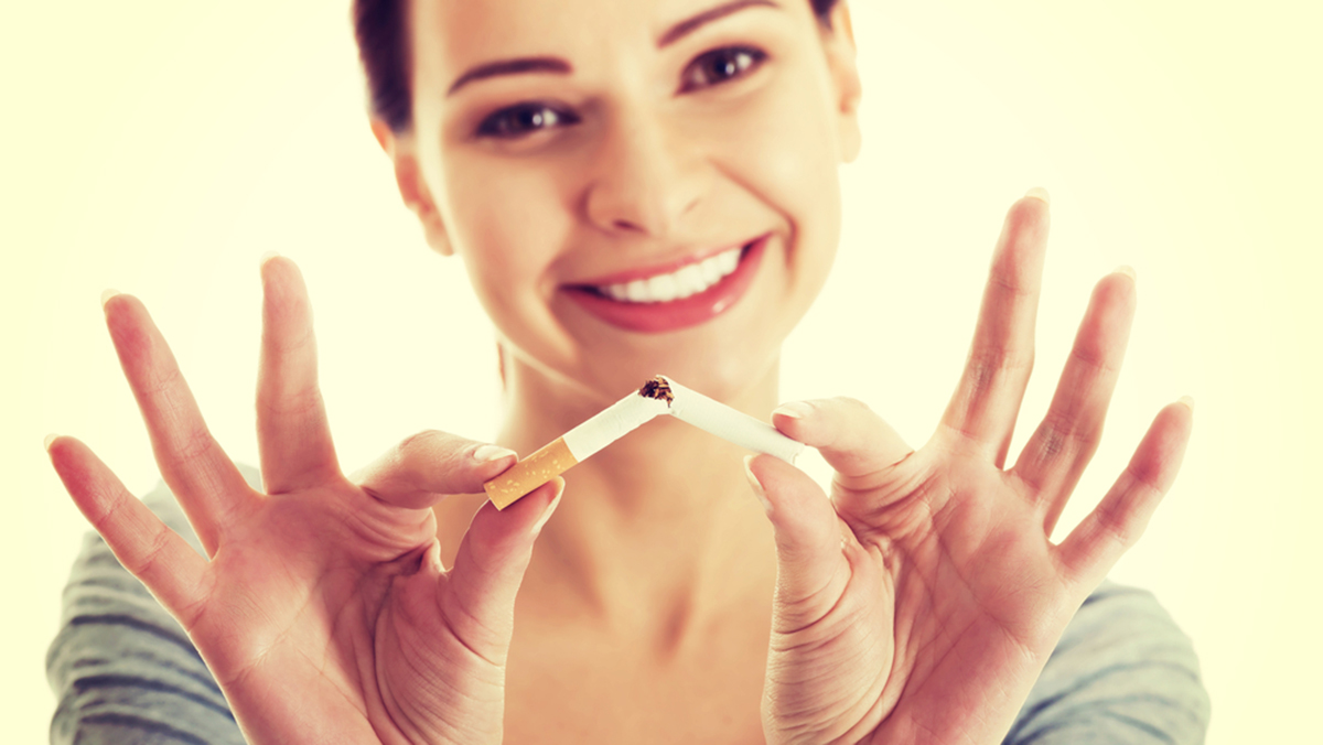 Young beautiful woman holding broken cigarette in front.