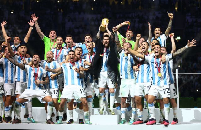 Soccer Football - FIFA World Cup Qatar 2022 - Final - Argentina v France - Lusail Stadium, Lusail, Qatar - December 18, 2022 Argentina's Lionel Messi celebrates with the trophy and teammates after winning the World Cup REUTERS/Carl Recine