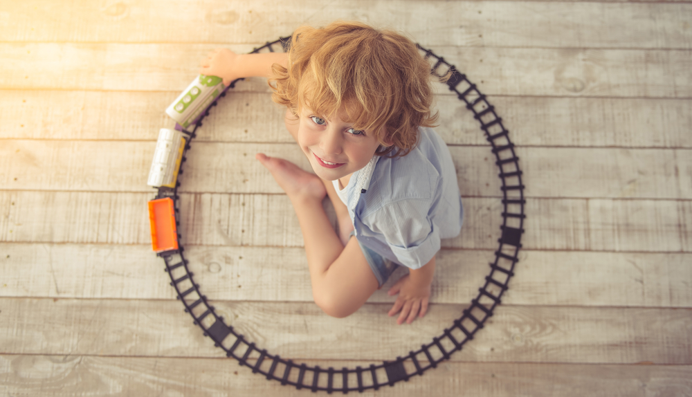 Top,View,Of,Cute,Little,Boy,Playing,With,Toy,Train,