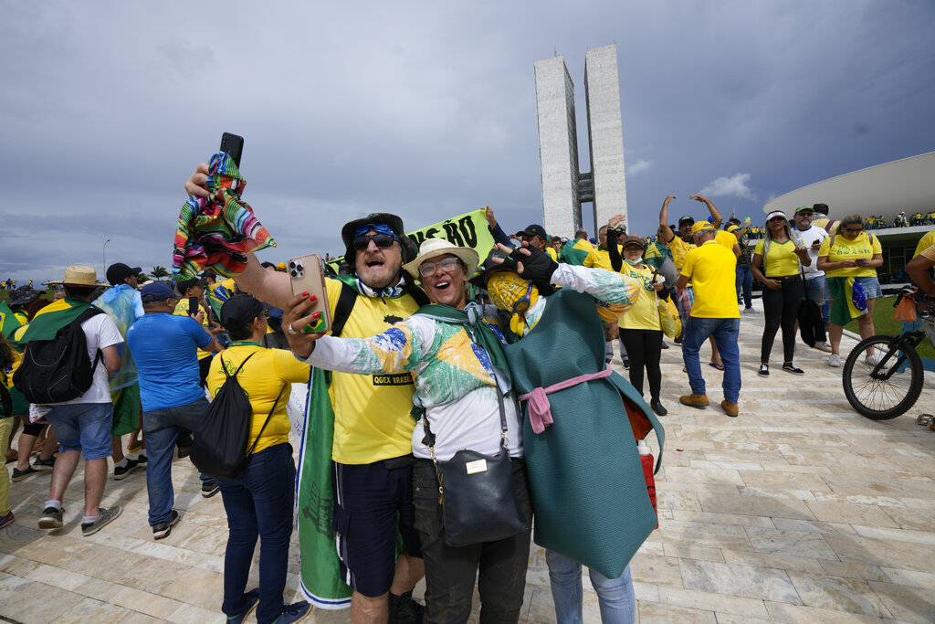 Protesters, supporters of Brazil's former President Jair Bolsonaro, take selfies as they storm the the National Congress building in Brasilia, Brazil, Sunday, Jan. 8, 2023. (AP Photo/Eraldo Peres)