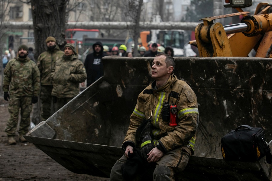 An emergency worker rests at the site where an apartment block was heavily damaged by a Russian missile strike, amid Russia's attack on Ukraine, in Dnipro, Ukraine January 15, 2023. REUTERS/Yevhenii Zavhorodnii