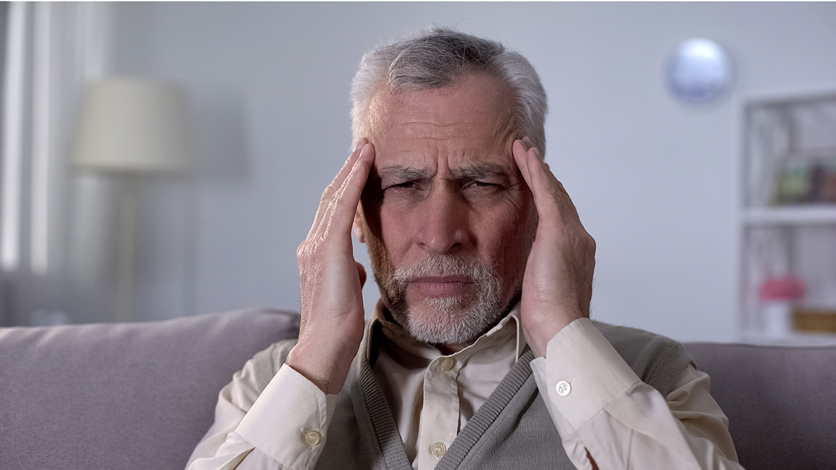 Old man suffering migraine, symptom of ischemic stroke, neurological problems