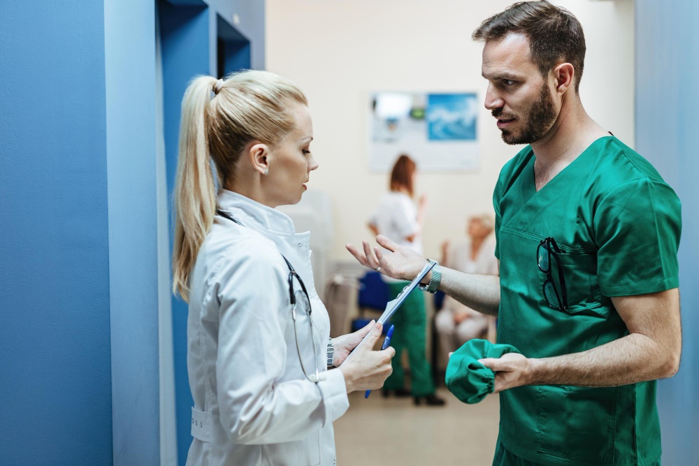 young-surgeon-female-doctor-communicating-while-standing-lobby-clinic