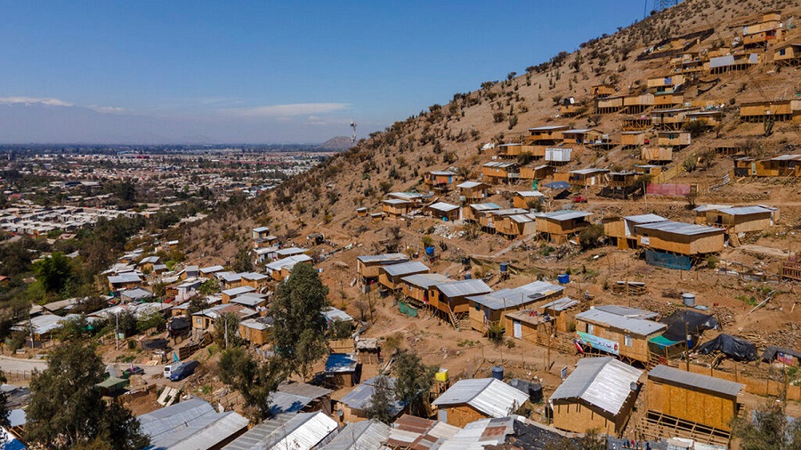 Homes stand on the side of a hill in an unpaved area named "Bosque Hermoso," or Beautiful Forest, where migrants from Haiti, Peru and Colombian settled in Lampa, Chile, Friday, Oct. 1, 2021. The situation of the migrants became more difficult in 2018 when Chile’s government issued a decree requiring that Haitians obtain a consular visa before traveling to Chile, then last April enacted a new migration law that seeks to prevent the irregular entry of foreigners. (AP Photo/Esteban Felix)