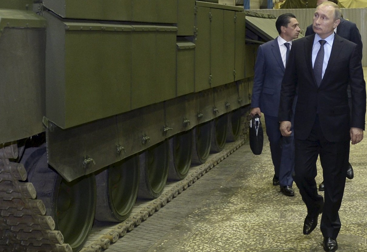 Russian President Vladimir Putin (L) listens to Andrei Terlikov, the head of the Ural Transport Machine Building Design Bureau, as they watch Russian infantry fighting vehicle with the Armata Universal Combat Platform and a T-14 Armata main battle tank at he Uralvagonzavod factory in the Urals city of Nizhny Tagil, Russia November 25, 2015. Speaking on a trip to the Ural mountains city of Nizhny Tagil, Putin ordered the despatch of an advanced weapons system to Russia's Khmeimim air base in Syria's Latakia province. REUTERS/Alexei Nikolskyi/Sputnik/Kremlin ATTENTION EDITORS - THIS IMAGE HAS BEEN SUPPLIED BY A THIRD PARTY. IT IS DISTRIBUTED, EXACTLY AS RECEIVED BY REUTERS, AS A SERVICE TO CLIENTS.      TPX IMAGES OF THE DAY