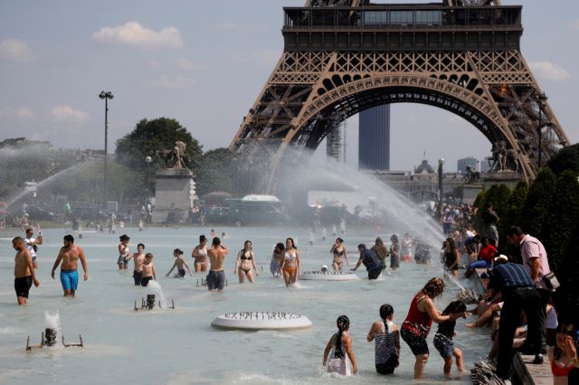 People cool off in the Trocadero fountains across from the Eiffel Tower in Paris as a heatwave hit much of the country, France, June 25, 2019. REUTERS/Charles Platiau