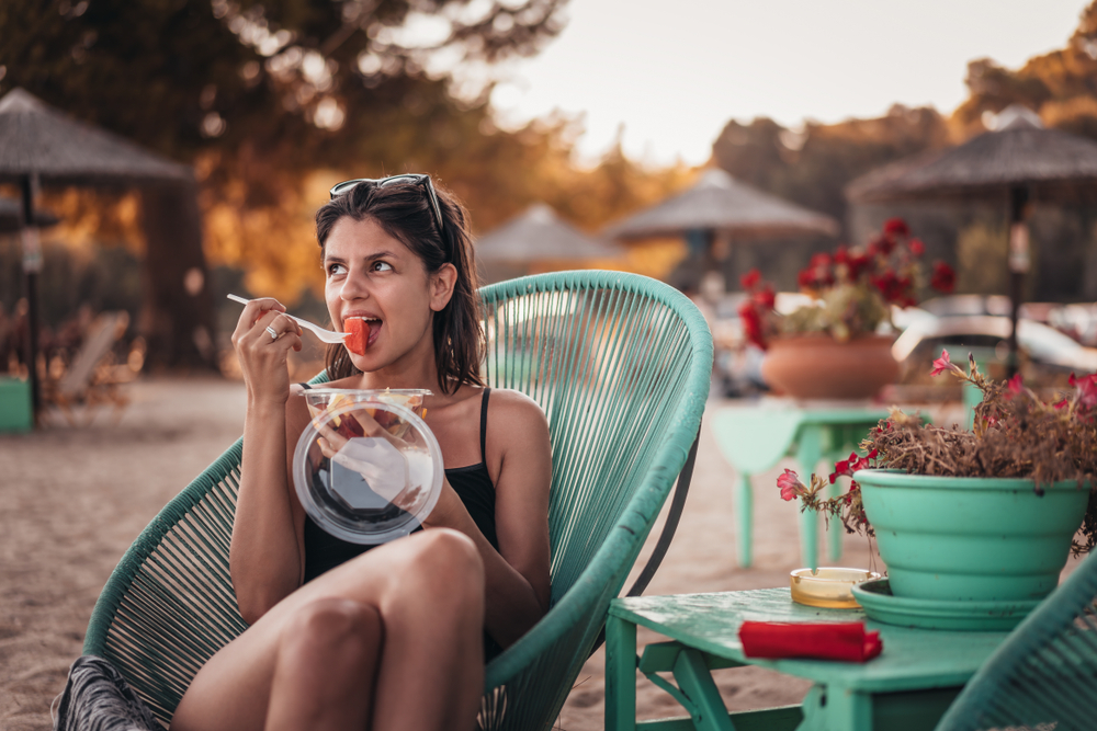 Beautiful,Female,In,Beach,Bar,Eating,Fruit,Salad