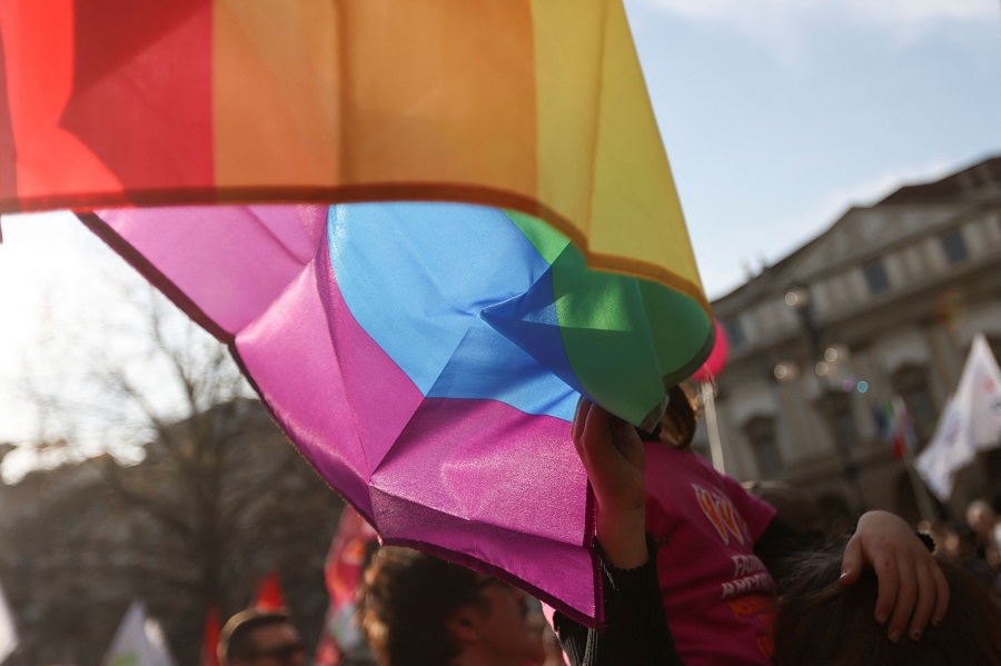 A child of a same-sex couple touches the LGBT flag at a protest after Italy's right-wing government told Milan's city council to stop registering same-sex parents' children in Milan, Italy March 18, 2023. REUTERS/Claudia Greco