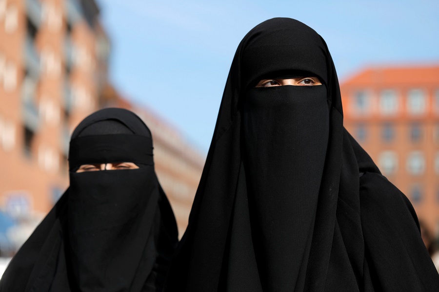 Aisha 18 and Alaa, 22, members of the group Kvinder I Dialog and wearer of the Islamic clothing the niqab, pass out flyers to promote their group's protest against the Danish face veil ban which will come into effect August 1, 2018, in Copenhagen, Denmark, July 31, 2018.  REUTERS/Andrew Kelly