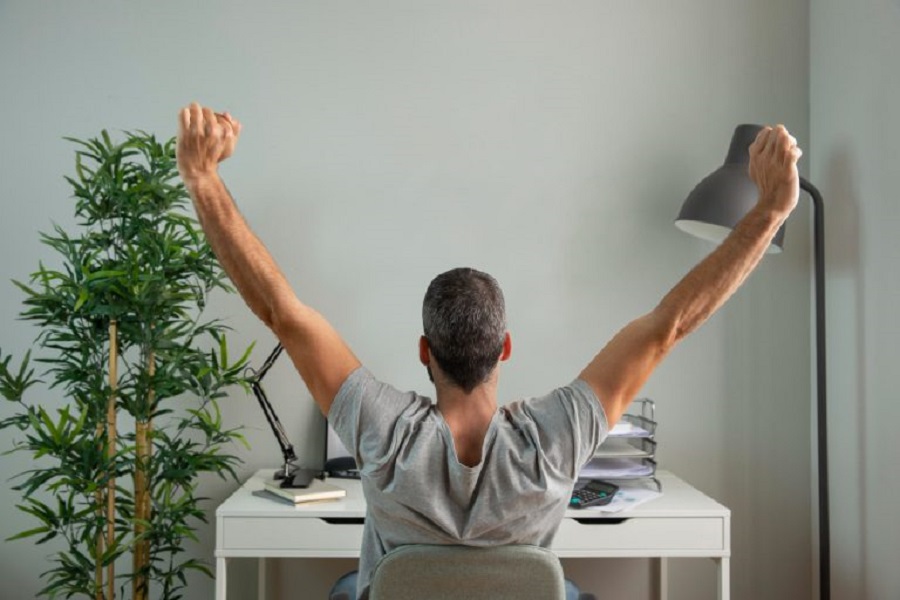 back-view-man-stretching-his-arms-while-working-from-home-