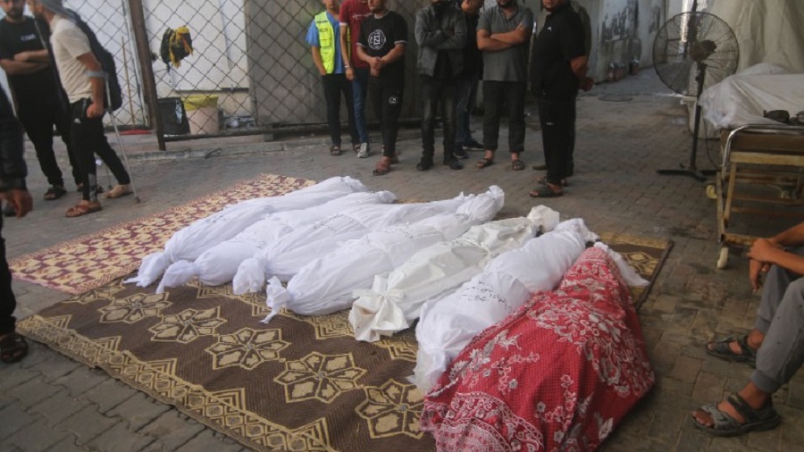 Palestinians stand around the bodies of the Awaja family killed in the Israeli bombardment of the Gaza Strip in Rafah, Friday, Oct. 20, 2023. (AP Photo/Hatem Ali)