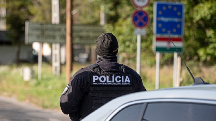 A Slovak police officer stands at the Hungarian-Slovakian border crossing point between Somoskoujfalu, Hungary, and Satorska Bukovinka, southern Slovakia, Thursday, Oct. 5, 2023. Slovakia began conducting traffic checks on its border with neighboring Hungary on Thursday amid what it says is a dramatic rise in migrants crossing onto its territory, part of a flurry of similar border measures other Central European countries have imposed in recent days.  (Peter Komka/MTI via AP)