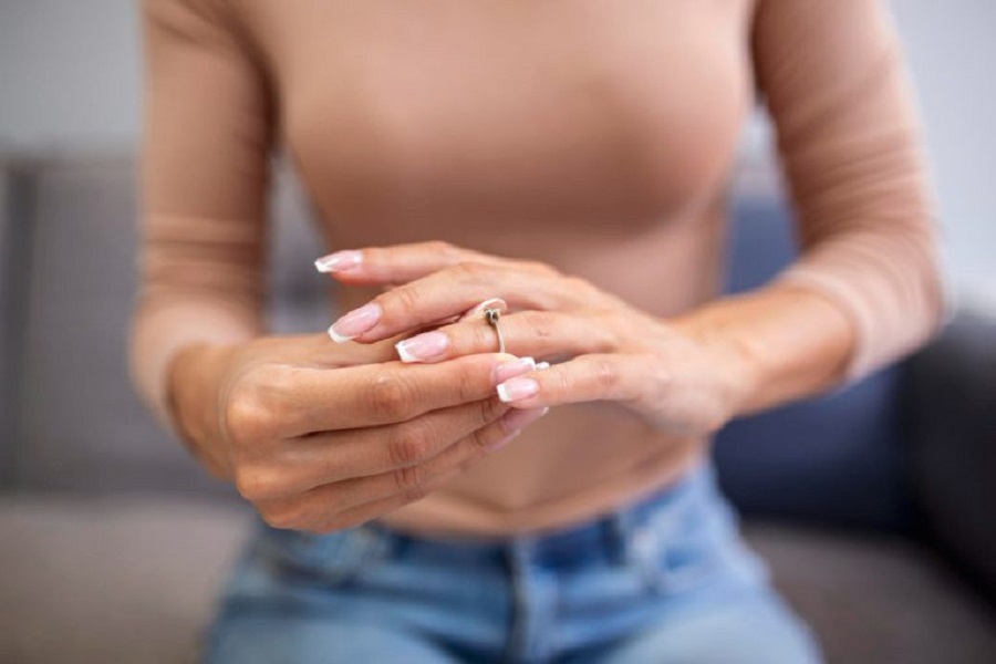 close-up-young-woman-taking-off-wedding-ring-jpg