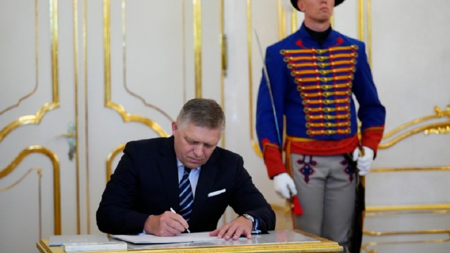 Newly appointed Slovakia's Prime Minister Robert Fico signs the oath during a swear in ceremony at the Presidential Palace in Bratislava, Slovakia, Wednesday, Oct. 25, 2023. Slovakia's president swore in on Wednesday a new government led by a former populist prime minister who is set to end his country's military aid for Ukraine fighting the Russian invasion. (AP Photo/Petr David Josek)