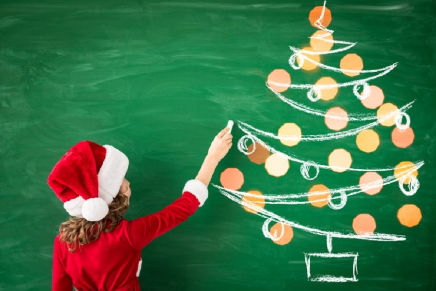 happy-child-wearing-santa-claus-draws-green-blackboard-