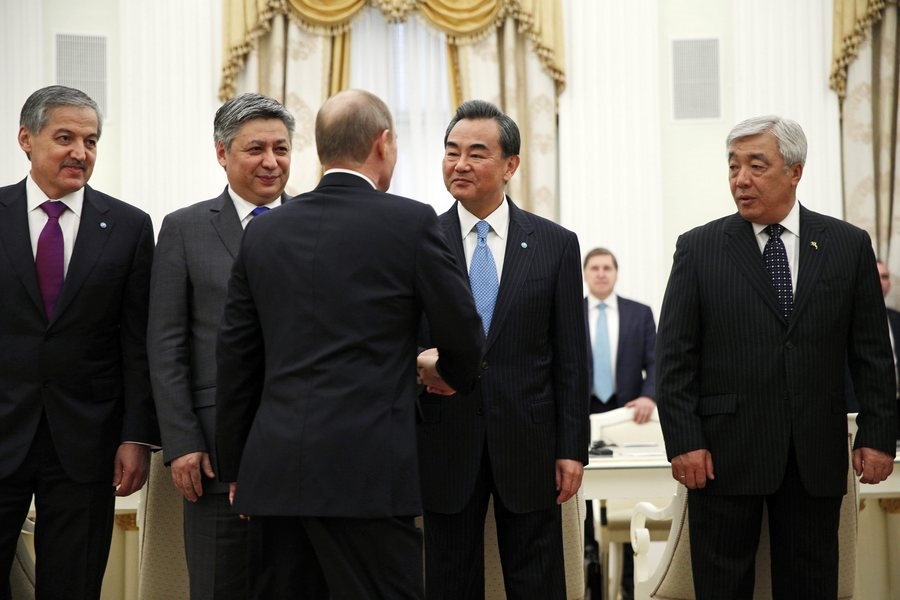 epa04781401 Russian President Vladimir Putin (with his back) shakes hands with Chinese Foreign Minister Wang Yi (2-R) as Tajikistan's Foreign Minister Sirodzhidin Aslov (L), Kyrgyzstan's Foreign Minister Erlan Abdyldayev (2-L) and Kazakhstan's Foreign Minister Erlan Idrissov (R) look on during a meeting with foreign ministers of the Shanghai Cooperation Organization (SCO) in Moscow, Russia, 03 June 2015. Putin met SCO foreign ministers to discuss key aspects of SCO activities, as well as preparations for the SCO summit scheduled on 9-10 July 2015 in Ufa.  EPA/PAVEL GOLOVKIN / POOL