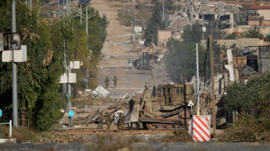 FILE - Israeli soldiers stand on Salah al-Din road in central Gaza Strip on Friday, Nov. 24, 2023, as the temporary ceasefire went into effect. The Israeli military has rounded up hundreds of Palestinians across the northern Gaza Strip, separating families and forcing men to strip to their underwear before trucking some to an undisclosed location. The roundups have laid bare an emerging tactic in Israel's ground offensive in Gaza, experts say, as the military seeks to solidify control in evacuated areas in the north and collect intelligence about Hamas operations nearly 10 weeks after the group's deadly Oct. 7 attack on southern Israel. (AP Photo/Hatem Moussa, File)