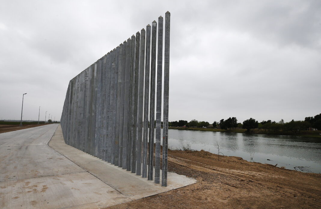 epa08270244 A privately built fence or border wall runs along the Rio Grande River on the United States side near McAllen, Texas, USA, 04 March 2020. The nearly two thousand mile United States Mexico border is the most frequently crossed international border in the world.  EPA/LARRY W. SMITH