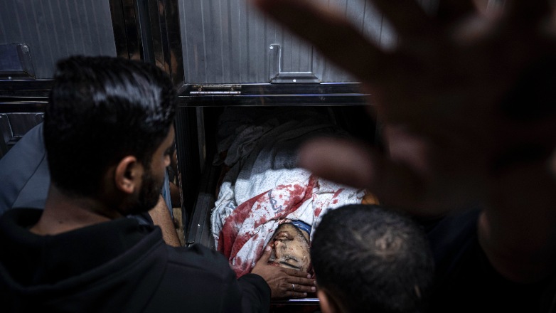 A mourner touches the body of a Palestinian man killed in an Israeli airstrike, in the morgue of Al-Shifa Hospital in Gaza City on May 9, 2023. The Israeli military said it killed three senior commanders of the militant Islamic Jihad group in targeted airstrikes. Palestinian health officials said 12 people were killed in total in Tuesday's attacks, including the commanders, their wives, several of their children and others nearby. (AP Photo/Fatima Shbair)